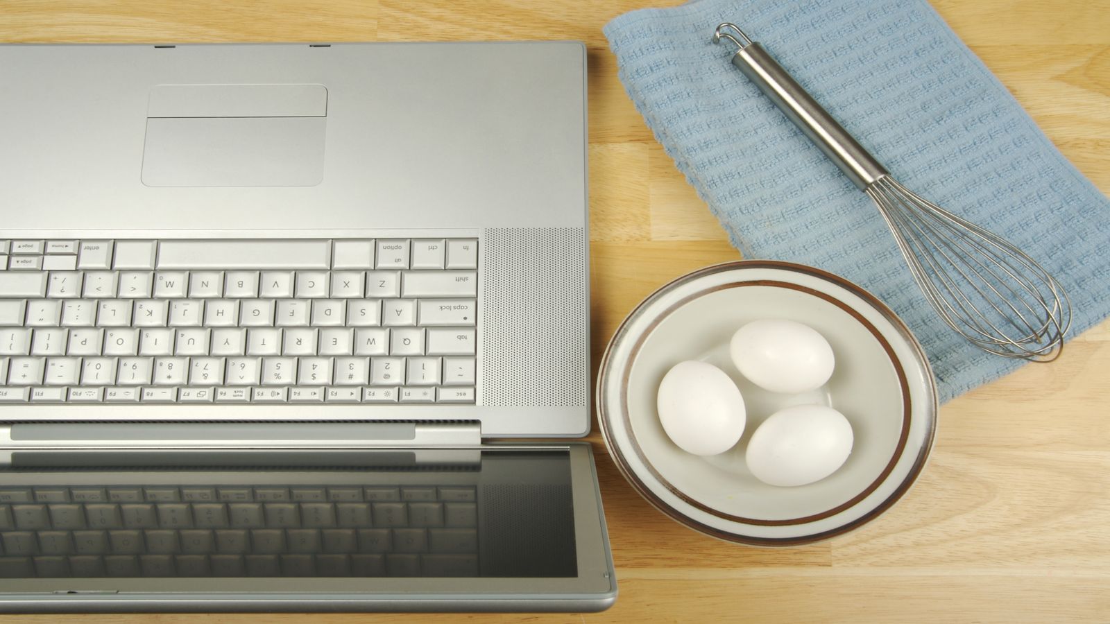 A kitchen timer beside an open notebook with hand-drawn focus session diagrams and a laptop